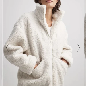 Lång teddyjacka med dragkedja  - Säljer min otroligt sköna teddyjacka i naturvit som jag köpt i våras på nakd. Endast använd max 2 gånger pga fel strl.   Yttertyg: 100% Återvunnen polyester. Foder: 100% Polyester.  Nypris 999kr