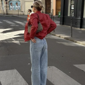 Röd skinnjacka  - Röd skinnjacka i höstens färg, storlek 42 men sitter perfekt oversize på en xs-m. Materialet är lite sprucket i kragen bak, se bilder. Inget som stör när man väl har den på men säljes därför för en billig peng! 