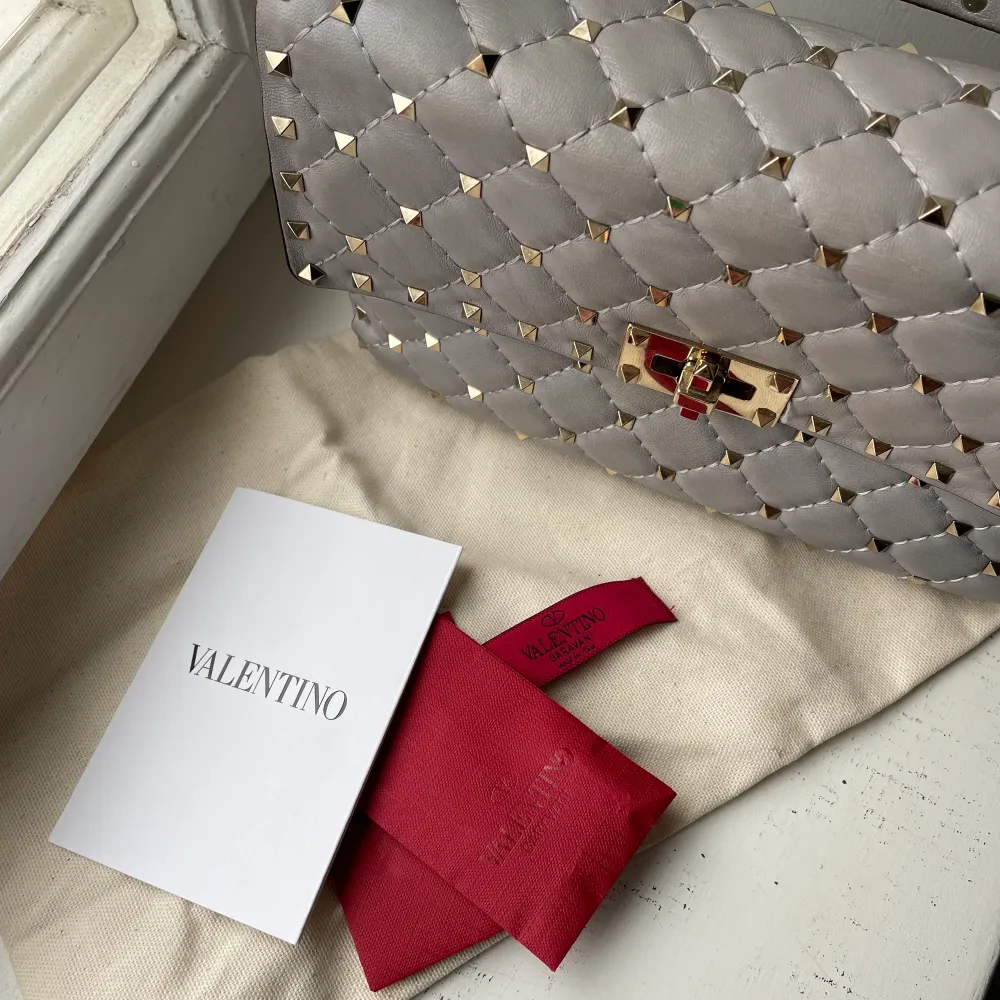 Säljer min Valentino Rockstud i medium i grått. Köpt 2018 i Valentinos butik i Cannes, har kvar kvitto, dustbag och extra nitar.  Sparsamt använd men på vissa ställer ser man naturligt slitage, kan skicka fler bilder:). Väskor.