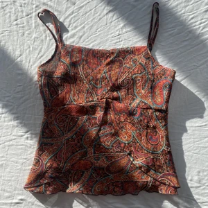 Vintage topp mönster - Underbar topp med babydoll stil. Storlek 10 på lappen vilket motsvarar M, kan nog passa L också. För stor på mig som är en size S med mindre byst. Har en deflekt på sidan (se bild 3) men är på sidan så syns inte så tydligt och går att laga. Köps via Swish