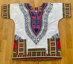 Dashiki topp, strlk small i nyskick  - Afrikansk Dashiki blus/topp i nyskick, aldrig använd. Storlek small. 100% bomull. Djur- o rökfritt hem.