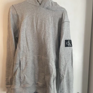 Calvin Klein Hoodie - En helt oanvänd Calvin Klein hoodie som jag nu har vuxit ur.