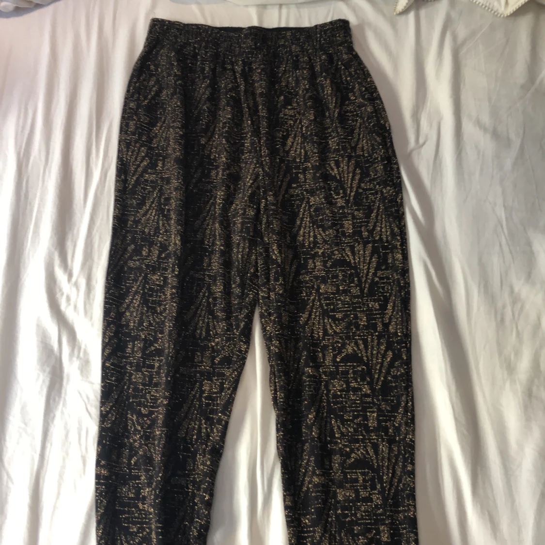 Svarta byxor med guldigt mönster