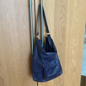 Lila väska - Mörklila väska köpt second hand. Så snygg men kommer inte till användning. Lite sliten på vissa ställen men i helhet är den fin. Köp direkt i appen för 80kr