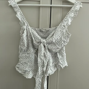 Prickig  knyt topp - Prickig  knyt topp från Nelly. Andra bilden visar hur den sitter på.  