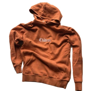 Château-hoodie - Orange hoodie, inget tryck på ryggen. Köpte secondhand och saknar därför snören till huvan. Lappen säger storlek S men passformen känns mer som M.