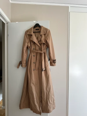 Trenchcoat  - Helt ny, knappt använd. Står att storleken är 46 men skulle säga att den är en 42:a.