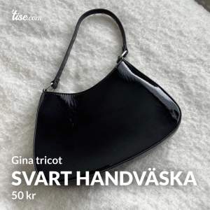 En svart handväska i glansigt material från Gina Tricot. Använd ca 1-2 gånger
