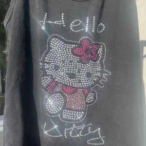 Hello Kitty strass linne  - Köpt second hand för något år sedan. Varsamt använd. Några diamanter har fallit av men det är kvavt märkbart. 