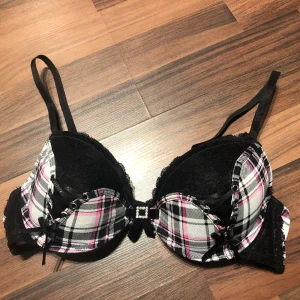 Rutig bh med rosetter - Rutig bh med snygga rosetter. Lappen är borta men det är strl 75B/80B. Frakt på 69kr tillkommer