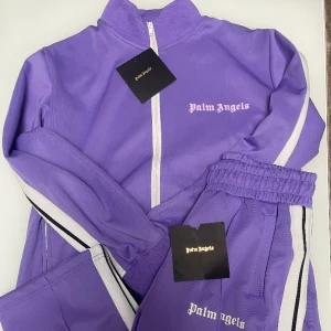 Lila Palm Angels dress  - Säljer en Palm Angels dress i färgen lila, passa på och köp!! Storlekar Byxorna L och tröjan M pris kan diskuteras