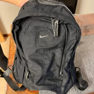 Nike ryggsäck - En stor och rymlig ryggsäck med flera fack. Dragkedjan är lite skadad (har lagt in en bild) men annars funkar den bra och är mycket rymlig. Köparen står för frakten ❤️