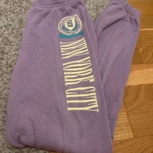 Mjukisbycksor  - Lila mjukisbyxor står New york city på. 55% bomull och 45% polyester.