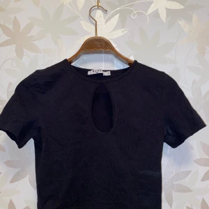 Top med cut out - Svart top med cut out över bröstet. Från NA-KD. Använd men i bra skick. 