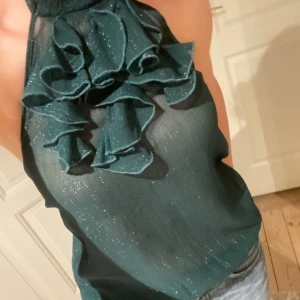 Festtopp med volanger - Så snygg halterneck topp i underbar mörkgrön färg med volanger och skimmer🪩💞Perfekt nu till jul&nyår! Passar S-M. Skriv vid funderingar och kolla in mina andra annonser😇