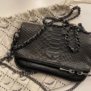 Zadig & Voltaire väska - Säljer denna super coola Zadig & Voltaire väskan med ormskinn-imitation!!💕 Nästan som ny! Passa på och köp denna unika väska, eftersom den inte finns att köpa längre!😍 Värde av ca 3000 kr, säljer för 1500 kr, men pris kan diskuteras! Helt utan defekter🙏🏽💕
