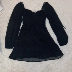 Svart Divided klänning - Säljer denna festklänning då den är för liten. Den har knappts andvändts och är i ett väldigt bra skick.