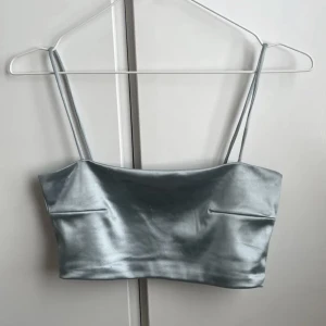 Blå skimrig topp - Blå skimrig topp från weekday💕 Toppen har små slitagemärken som man ser tydligare på tredje bilden🫶den är mindre i storleken så passar bra på mig som oftast har storlek small💕