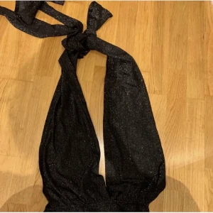 Body - Glittrig body med öppen rygg, strl S, har ingen bild på. Man knyter den runt nacken. 