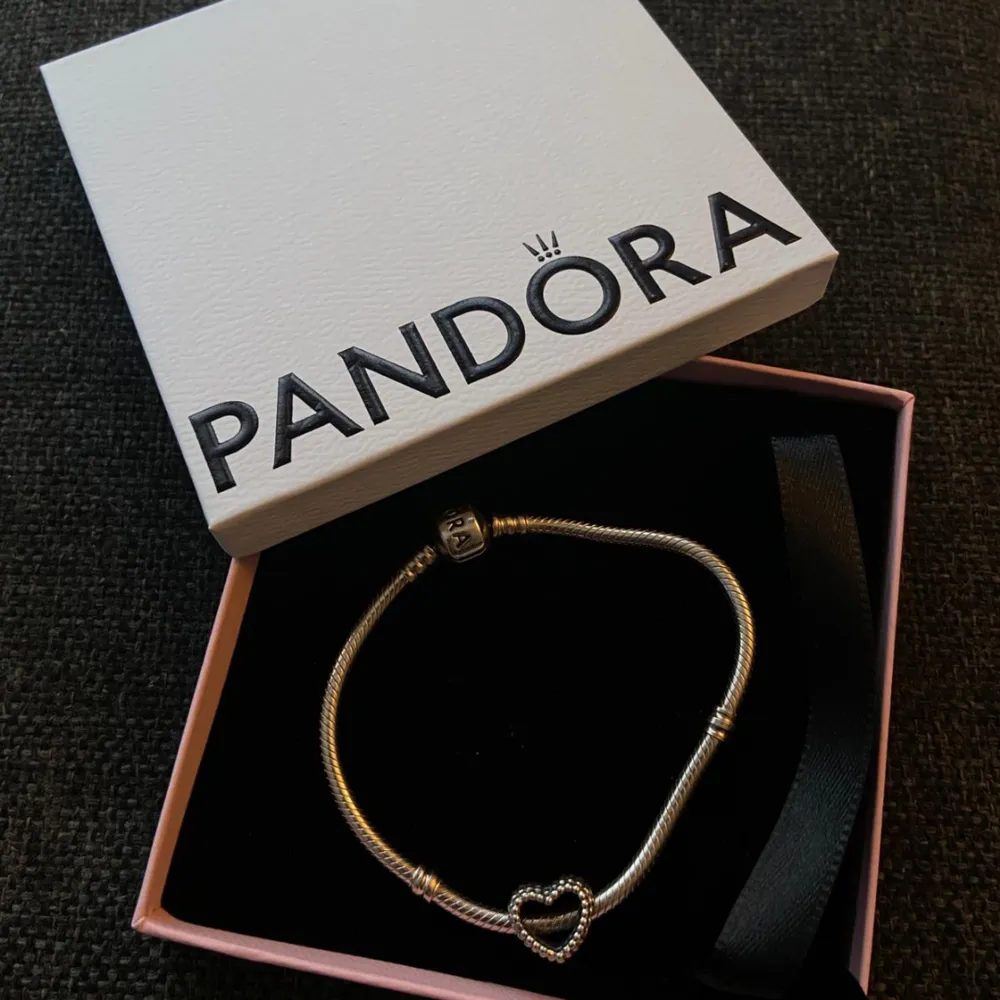 Äkta Pandora Armband i längd 19cm. Nypris 748 kr med hjärt berlock, säljs för 470 kr. Använt endast fåtal gånger. Hör av dig vid några frågor.. Accessoarer.