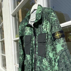 Stone Island Green Alligator Camo Jacket - Hej, säljer en unik och sällsynt jacka från Stone Island. Fantastisk kvalite. Grön Camo. Storlek L men passar även M. Såldes på Circle Fashion för <6000kr. Bra skick CLG-kod bevisar äkthet. ”Anti drop” perfekt inför hösten. Pris kan diskuteras. Hör av er!