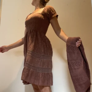 Klänning m stickad scarf - Fin klänning i gammelrosa med spets och virkade detaljer samt matchande stickad scarf. Nyskick.