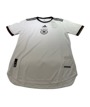 Tyskland - En Tyskland tröja i storlek M som är vit. Den är perfekt passande och av hög kvalitet. Dess andningsförmåga gör den idealisk för både matcher och träning.