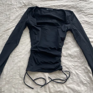 Svart topp - Svart topp köpt från Zara, räfflad på sidorna och går att justera till att göra kortare med hjälp av banden