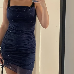 Glitter Kort Klänning - En glittrig kort klänning från Cider i marinblå. Säljer för den va för kort på mig (jag är 170cm). Har aldrig anvönt den, den kommer med etiketten. Riktiga priset är 219kr.