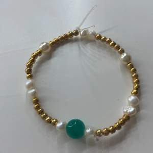 Fint armband med gröna, guldiga och vita pärlor