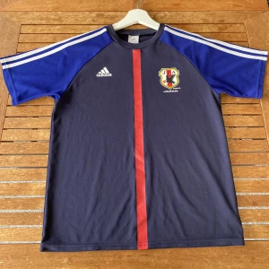 Japan Hemmatröja (retro) - Detta är Japans hemmatröja ifrån 2012. Tröjan är i storlek 164 men passar nog som en xs/s. Skick 8/10, lite nopprig men syns inte när den sitter på. Skicka till mig om du har frågor!