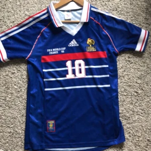 Zidan fotbollströja  - Hej säljer en helt ny zidane tröja från vm 98 tröjan är inte ändvänd för att den har suttit på vägen pris kan diskuteras