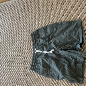 Gröna shorts  - Ett par basic gröna shorts från lager 157 med snören i beige. Helt nya, endast använt 20/30 min. Säljer pga att de inte kom till användning och att dem var för små, dock stora för storleken då de är storlek S och jag är 190 och nästan kunde ha dem. 