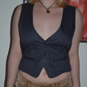 Punkig väst med guld detalj - As cool randig väst med guld detalj där bak. Secondhand fynd i bra skick. Pruta funkar bra!