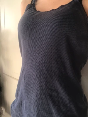 Mörkblått ribbat linne - Ett fint mörkblått linne som inte kommit till användning, har ”spets” runt halsen och i axelbanden. 