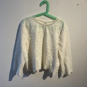 Topp - En vit topp med lite mönster, somrig med lite öppet i ryggen kort i armen 