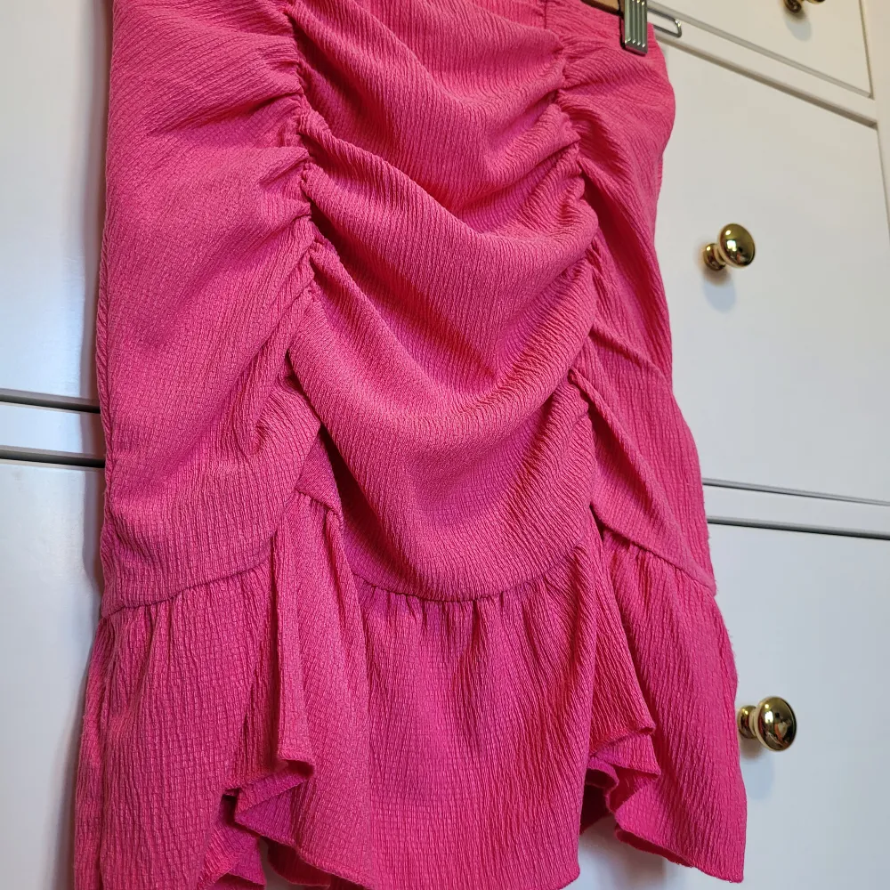 Oanvänd rosa minikjol med en volang och scrunch från Gina Tricot! Jättesöt till sommaren! Köparen står för frakten, men kan mötas upp i Göteborg 🩷. Kjolar.