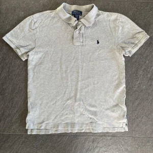 Polo Ralph Lauren kids  - Piké från Ralph Lauren kids. Ett litet hål bak i nacken. Annars fin!