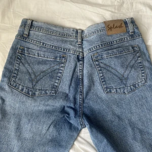 Lågmidjade och vida jeans från Splash - Låga & vida jeans från märket splash. Köpte second hand och säljer eftersom de är för korta för mig. Det står att de har storlek 31/34 och jag skulle säga att det funkar för S/M Mått:  Midja: 39.5 cm Höfter: 50-52 cm Längd: 97 cm Pris går att diskuteras! 