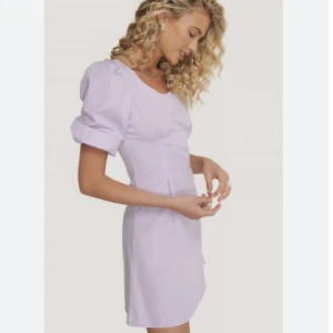 Klänning  - Pastell lila sommarklänning från NA-KD. Puffärmar och figursydd. Den har även en dragkedja på sidan.