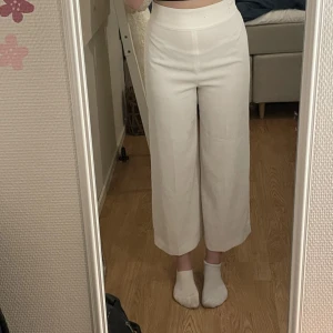 Vita kostymbyxor  - Vita kostymbyxor som slutar vid anklarna. 