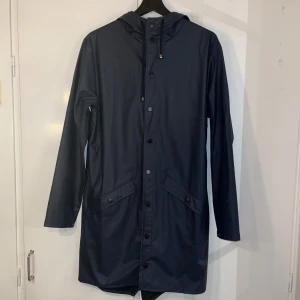 Rains jacket  - Regnjacka från Rains i storlek xxs/xs. Färg: Navy blue. Har en del fläckar. Längd: 157 cm 