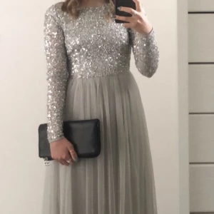 Balklänning  - Säljer min superfina silvriga balklänning från Asos. Märket är ”Maya Deluxe Petite”. Klänningen passar mig perfekt i längd som är 160cm. Enbart använd ett tillfälle så i ett mycket bra skick. Nypris 1419kr.