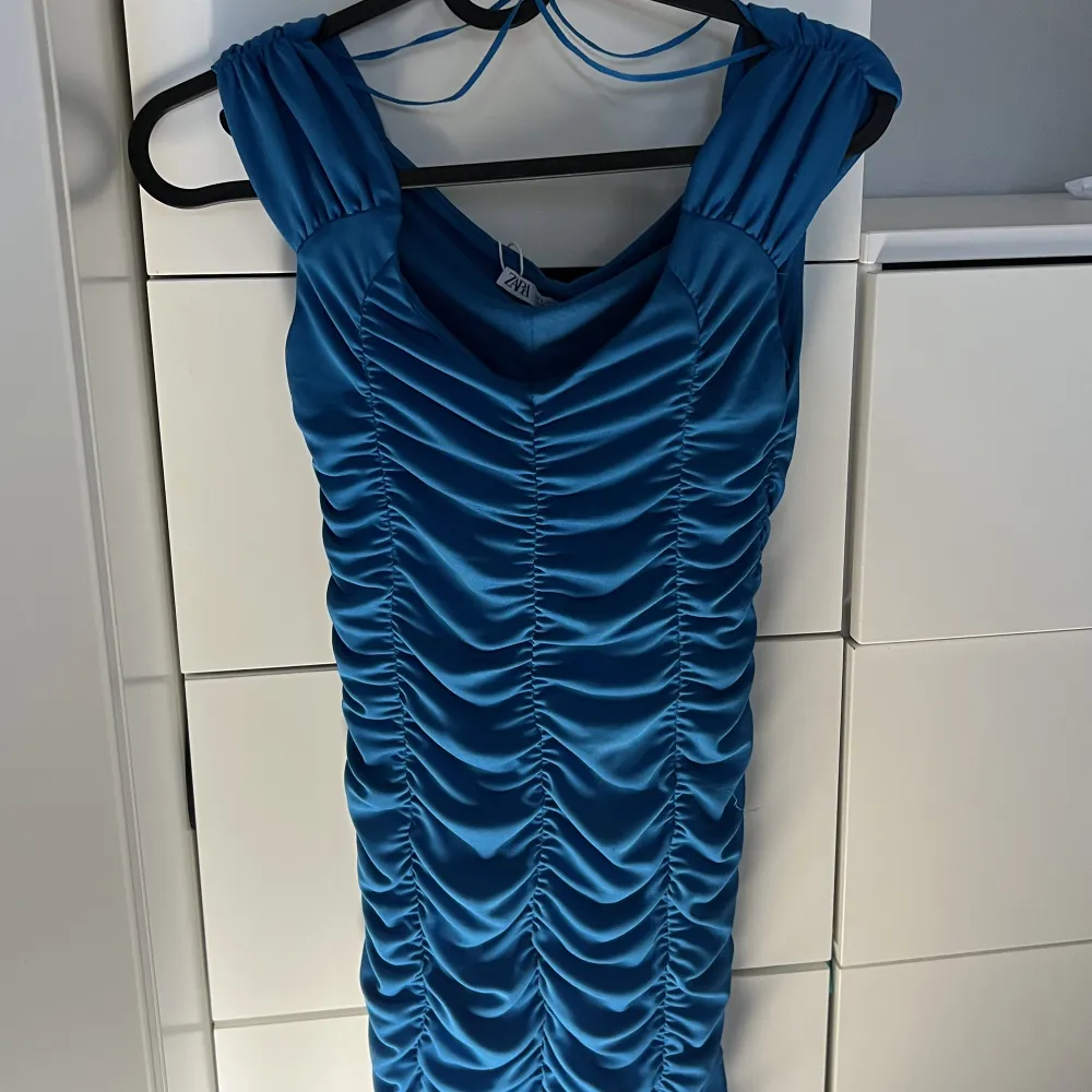 En blå klänning i nytt skick ! Köpte den här klänningen i Zara, Grekland sommaren 2022 och därpå använt den där bara en gång💕Säljs pågrund av att den e lite för kort för mig. Skulle säga att den är liten i storleken. Pris går att diskutera! . Klänningar.
