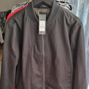 Jacka - Oanvänd i nyskick! Fint skogsgrönt foder på insidan.