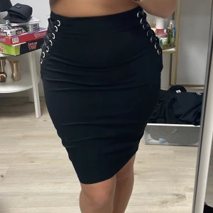 Bikbok midi kjol - Bikbok midi-kjol med snörning på sidan och dragkedja baktill. Storlek XS. Jag på bilden har storlek XS-S