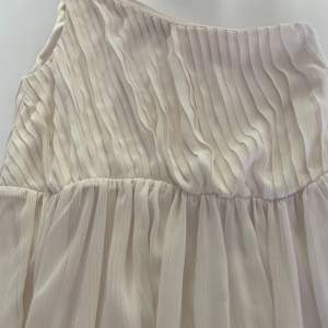 En vit klänning med en ärm i storlek 34