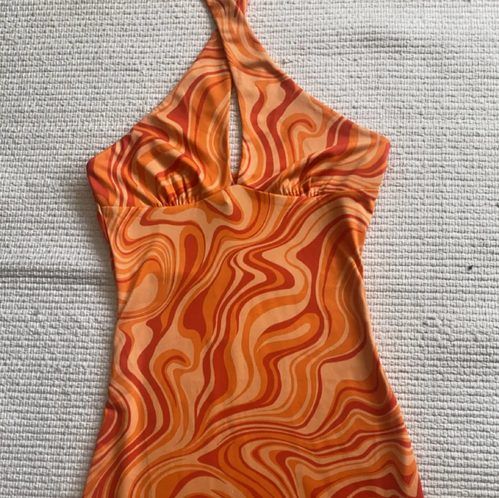 Orange klänning perfekt till sommaren och semester. Storlek XS. Går att både ha knuten där fram som på bilden eller ha den som vanligt. Endast använd en gång så precis som ny!💛 Köparen står för frakt!. Klänningar.