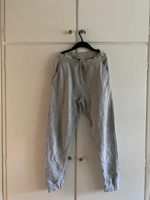 Gråa mjukisbyxor, SOC - Gråa mjukisbyxor i storlek M från Soc, endast använda ett fåtal gånger pga fel storlek. En lös tråd i midjemudden bak, annars fint skick 