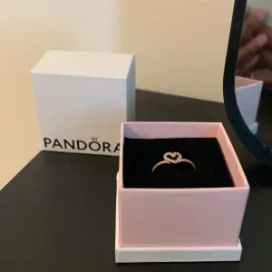 Säljer en Pandora-ring och den är, den senaste, aldrig använd. Säljer den för att jag tänkte att den kanske är för yngre tjejer eftersom den har ett hjärta i sig. Om du är från Sverige Stockholm, hör av dig så kan vi prata i detalj. Storlek 48 i ringstorl